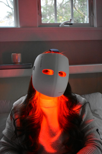 Allure contributing commerce writer Christa Joanna Lee using the TheraFace Mask Glo in red light mode